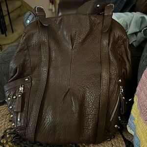 Brown studded handbag. Hobo style with small backpack straps.